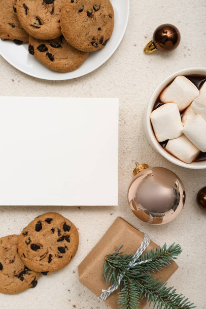 Tarjeta en blanco con galletas, taza de cacao, regalo de Navidad y bolas sobre fondo blanco - Foto, Imagen
