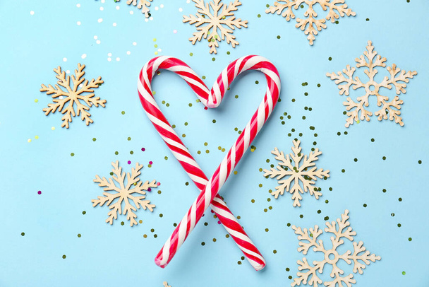 Sydän karkkia keppejä ja joulukoristeita värillinen tausta - Valokuva, kuva