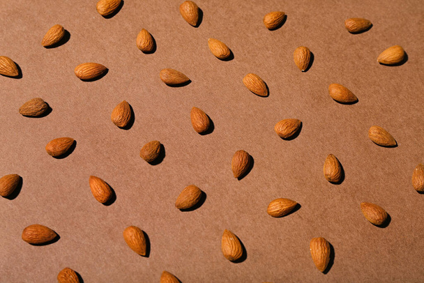 Many almonds on brown background - Foto, Imagen