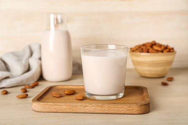 Стакан здорового миндального молока на деревянном столе - Фото, изображение