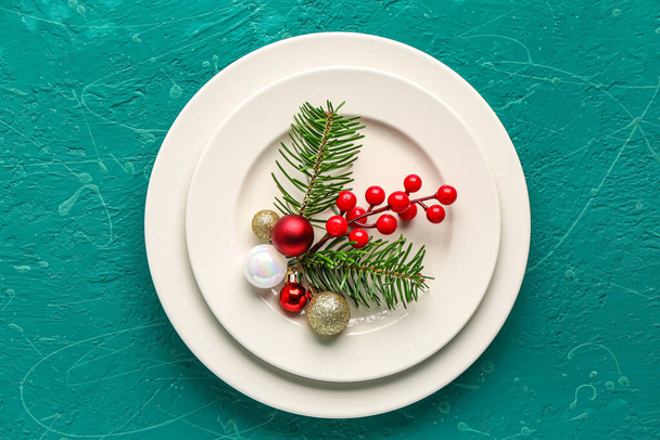 Fehér lemezek karácsonyi ágak, áfonya és labdák zöld háttér - Fotó, kép