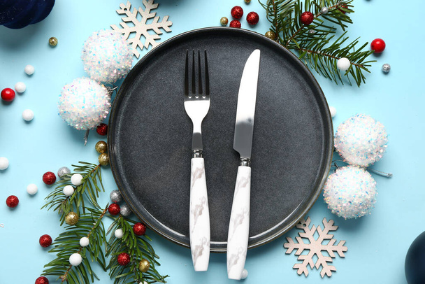Tischdekoration mit Weihnachtskugeln und Tannenzweigen auf blauem Hintergrund - Foto, Bild