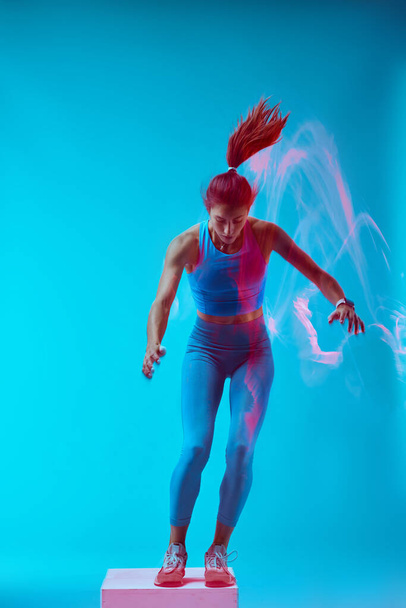 Una deportista haciendo saltos de caja y haciendo ejercicio. Movimiento de captura de larga exposición. - Foto, imagen