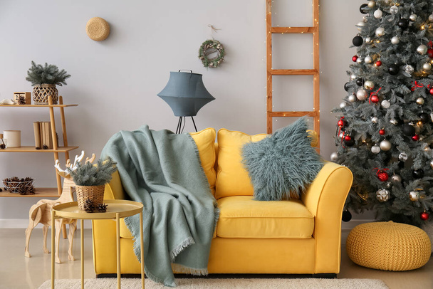 Εσωτερικό του σαλονιού με κίτρινο καναπέ και χριστουγεννιάτικο δέντρο - Φωτογραφία, εικόνα