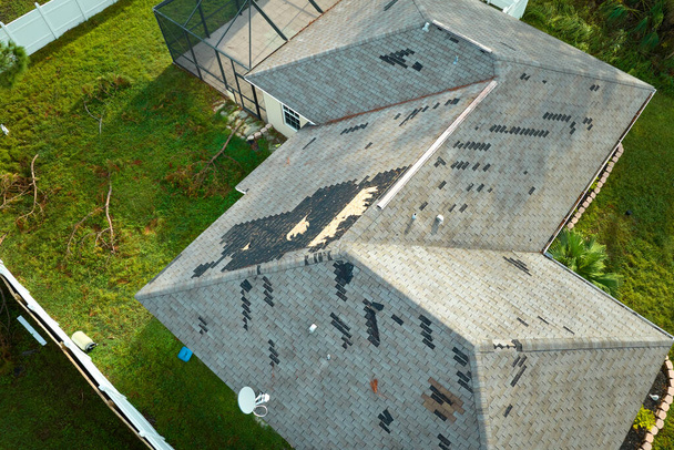 Poškozená střecha domu s chybějícími pásovými opary po hurikánu Ian na Floridě. Důsledky přírodní katastrofy. - Fotografie, Obrázek