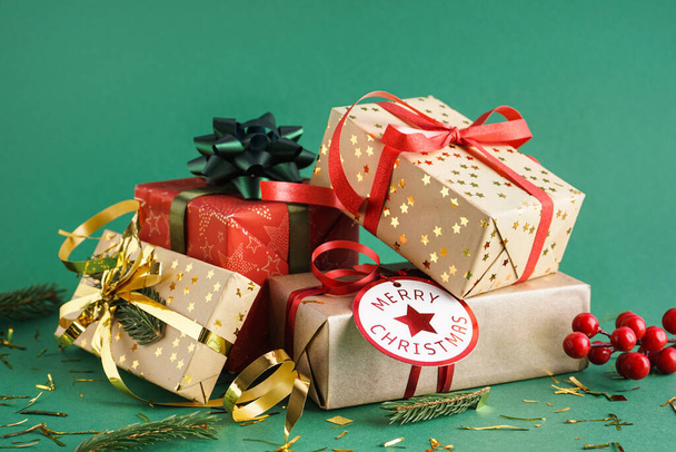 Cadeaux de Noël avec branches de sapin et confettis sur fond vert - Photo, image