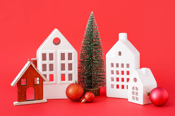 House shaped candle holders with Christmas toys on red background - Photo, Image