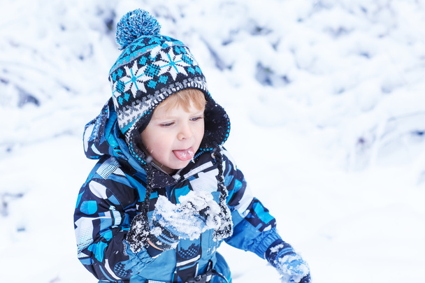 Adorable niño que se divierte con la nieve en el día de invierno
  - Foto, imagen