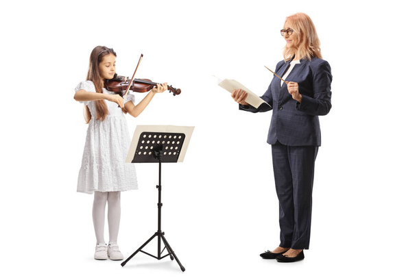 Music teacher holding a stick and paper and a girl playing a violin isolated on white background - Φωτογραφία, εικόνα