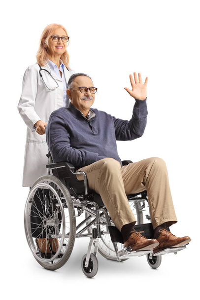 Male patient sitting in a wheelchair and waving and female doctor standing behind isolated on white backgroun - 写真・画像