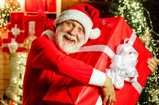 Brodaty Święty Mikołaj z prezentem świątecznym. Noworoczne wakacje. Przygotowuję się na Wigilię. Usługa dostawy - Zdjęcie, obraz