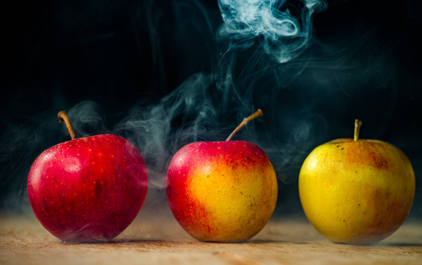 mele come la magia nel fumo mele fresche sul tavolo su uno sfondo scuro pieno di fumo magico - Foto, immagini