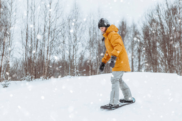Hoş bir genç kız kış parkında kar kayağı yapıyor, sağlıklı bir yaşam tarzı. - Fotoğraf, Görsel