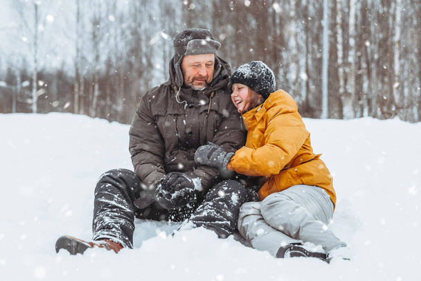 Padre e hija caminando por el paisaje nevado, caminata familiar en el parque de invierno. - Foto, imagen