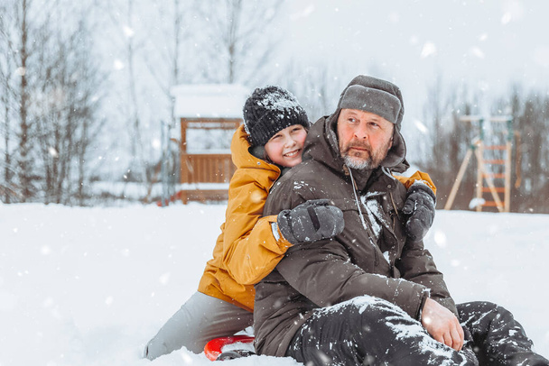 Батько і дочка гуляють по засніженому пейзажу, сімейні прогулянки в зимовому парку
. - Фото, зображення