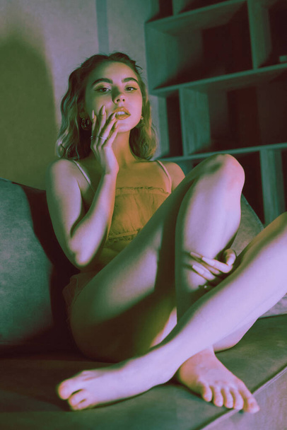 krásná mladá žena ve spodním prádle sedí na pohovce - Fotografie, Obrázek