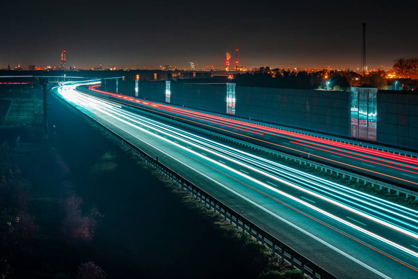 Traffico automobilistico in autostrada con schermi ad alta intensità energetica sotto la città, in lontananza si possono vedere gli edifici della città di Breslavia. - Foto, immagini