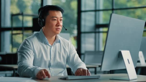 Asyalı işadamı danışman danışman danışman öğretmen yardım hattı şirketinde çalışıyor video sohbetiyle uzaktaki bir müşteriye online iş stratejisi tele pazarlama mesleğini anlat - Video, Çekim