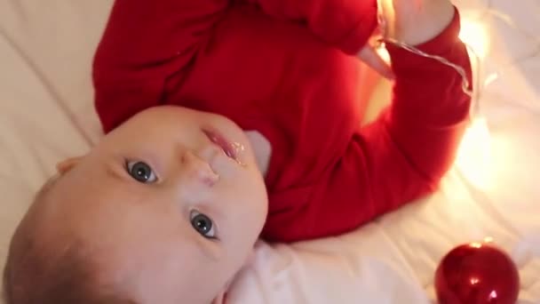 adorable bebé jugando con luces de Navidad - Metraje, vídeo