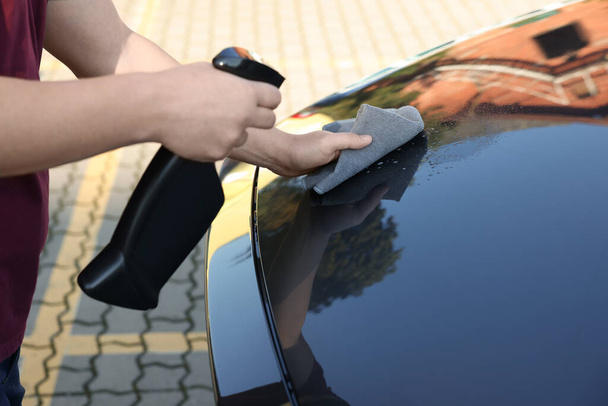 Man cleaning car hood outdoors, closeup view - 写真・画像