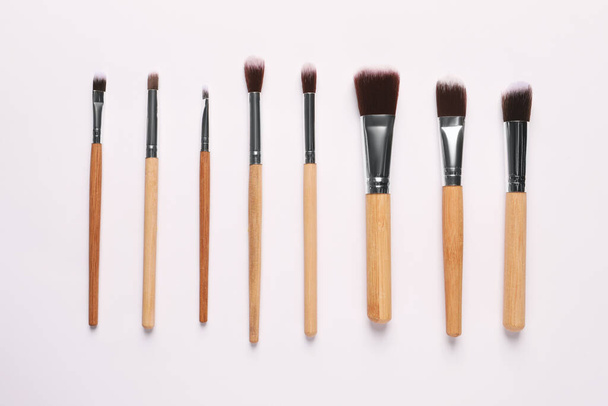 Different makeup brushes on white background, flat lay - 写真・画像