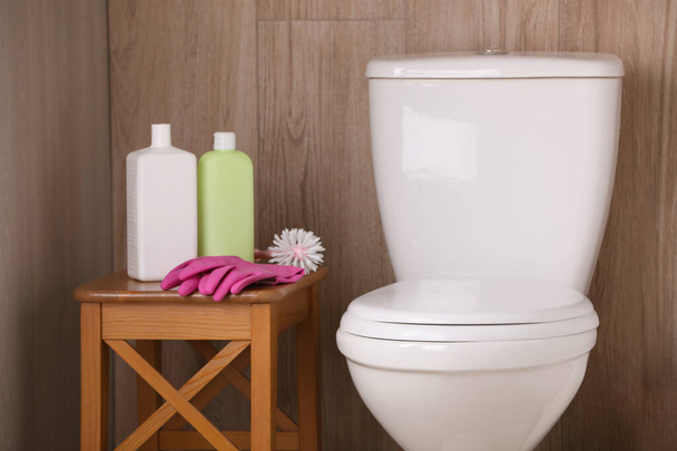 Cleaning supplies on stool near toilet bowl indoors - Photo, Image