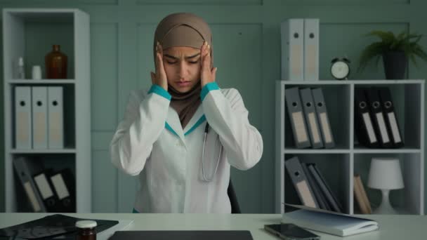 病気のアラビア語のイスラム教徒の女性過負荷疲れ医療労働者の医師医療は、頭痛のタッチ頭こする寺院に苦しむ痛みが悪い慢性片頭痛疾患病院での過労による健康障害 - 映像、動画