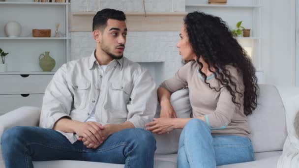 Worried Hispanic couple frustrated with quarrel conflict family problem arguing about breaking up divorce shouting loud disagreement sitting on couch misunderstanding difficult relationships trouble - Footage, Video