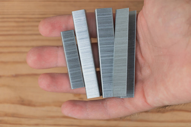 Metal staples for staple machine on in the hand of a man. - Foto, Imagen