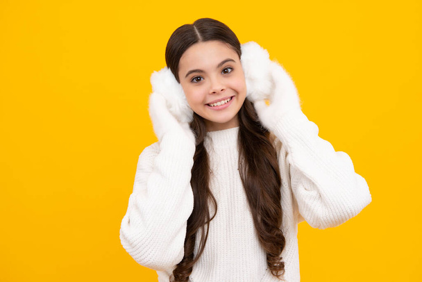 Mode glückliche junge Frau in warmen Ohrenschützer-Ohrenklappen und Pullover, die Spaß vor buntem blauen Hintergrund haben. Glückliches Gesicht, positive und lächelnde Emotionen des Teenie-Mädchens - Foto, Bild