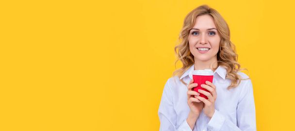 Blij blonde vrouw met koffie kopje in de ochtend op gele achtergrond. Vrouw geïsoleerd gezicht portret, banner met mock up kopieerruimte - Foto, afbeelding