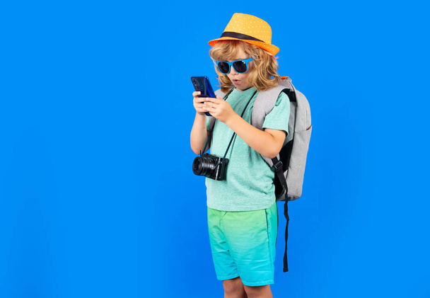 Traveler tourist kid boy 7-8 years old. Kid boy with mobile phone - Fotó, kép