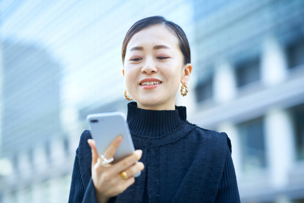 Business nainen katselee älypuhelimen näytön - Valokuva, kuva