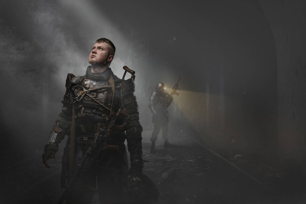 Retrato de superviviente post apocalíptico con escopeta mirando la luz en el polvoriento metro. - Foto, imagen