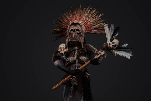 Знімок ацтекової відьми, одягнений у церемоніальний головний убір, що тримає персонал з черепом
. - Фото, зображення