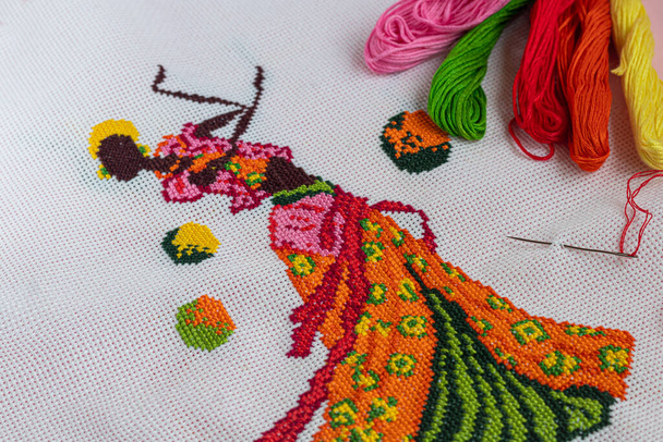 Handmade embroidery. Multicolored patterns on white fabric. Ethnic drawing. Copy space. - Photo, Image