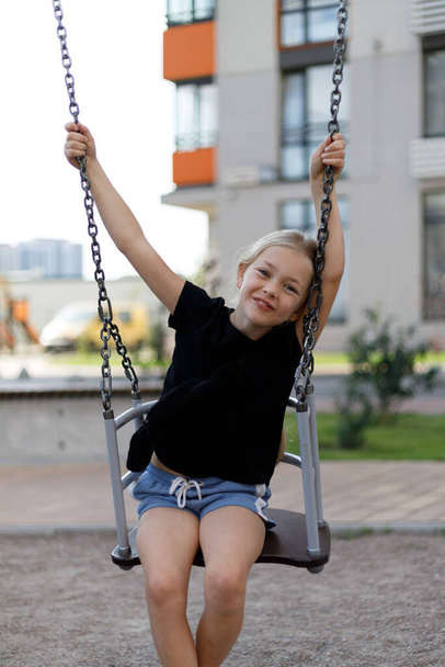 Happy child smiling on a swing, active lifestyle. - Фото, зображення