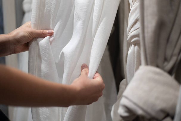 Fabric sale, retail shop with curtains. Buyer's hands, close-up. - Φωτογραφία, εικόνα