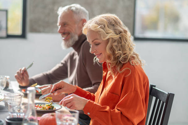 Yıldönümü. Masada oturup yemek yiyen olgun bir çift. - Fotoğraf, Görsel