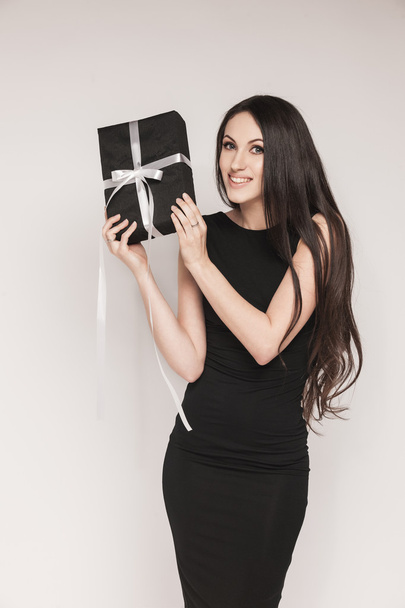 Sonriente mujer elegante sosteniendo regalo
 - Foto, Imagen