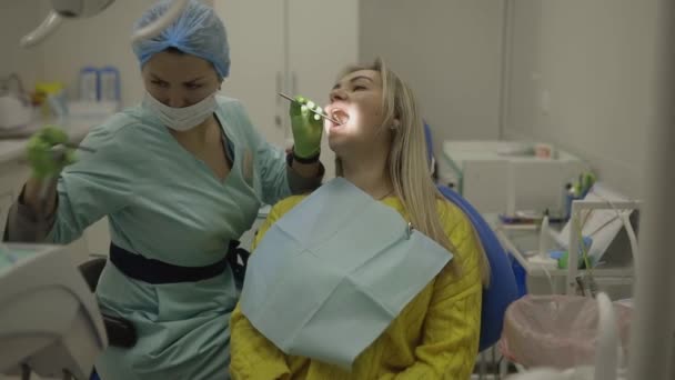 Koncepcja zdrowia dentystycznego. usta kobiety podczas leczenia w klinice stomatologicznej - Materiał filmowy, wideo