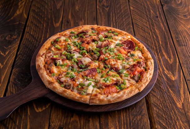 Garlic Surpreme pizza isolated on cutting board top view on dark background italian fast food - Fotografie, Obrázek