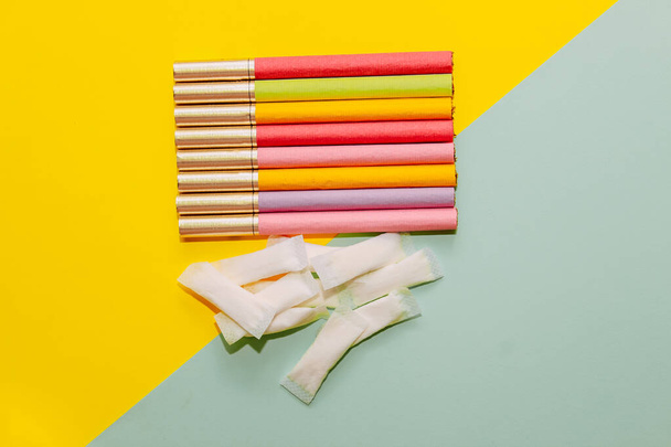 Multicolored cigarettes and snus pads on a paper background, the concept of a bad habit. - Foto, afbeelding