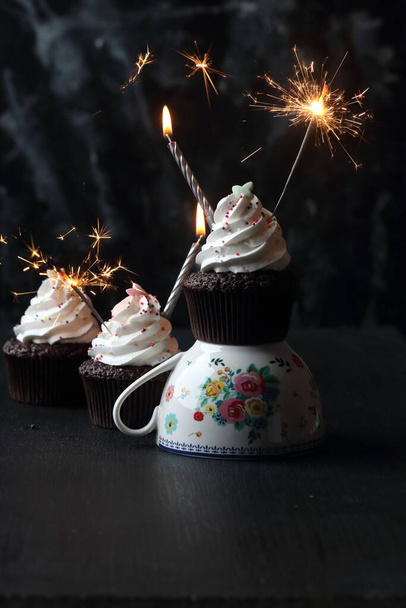 Cupcakes with candles and sparkler  on a black background - Photo, image