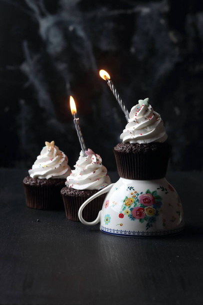 Cupcakes with candles on a black background - Foto, imagen