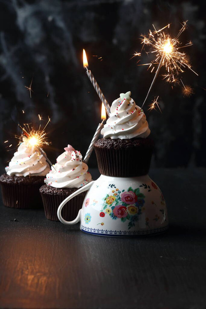 Cupcakes with candles and sparkler  on a black background - Foto, imagen