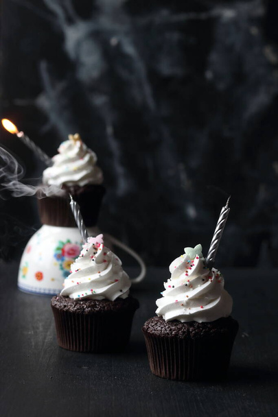 Cupcakes with candles on a black background - Foto, Imagen