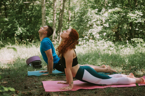 Coppia di yoga che fa qualche posa yoga nella foresta - Foto, immagini