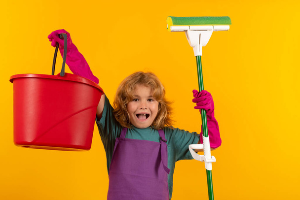 Limpieza de casa. Estudio retrato aislado de la casa de fregar niño, limpieza de la casa. Detergentes y accesorios de limpieza. Servicio de limpieza. Pequeño chico divertido ama de llaves - Foto, imagen