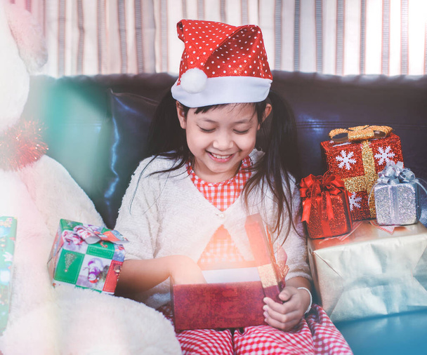 Καλά Χριστούγεννα και καλές γιορτές! Χαρούμενο χαριτωμένο μικρό κορίτσι ανοιχτό κουτί και ανταλλαγή δώρων, μικρά παιδιά που διασκεδάζουν στο σπίτι με δώρα στο δωμάτιο - Φωτογραφία, εικόνα